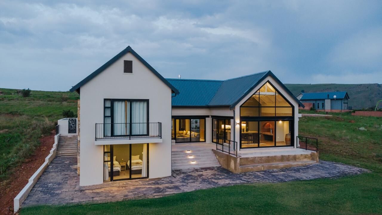 861 Highland Gate at dusk, its glass gable lit from inside